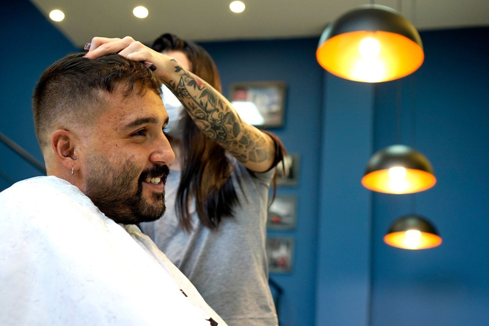 Cliente e barbeira conferindo o corte pronto